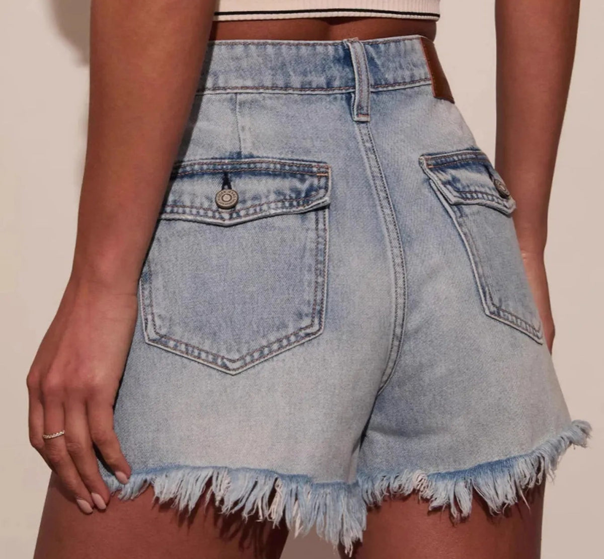 Damen Jeans Shorts mit Gesäßtaschen und offenem Fransensaum in Rückansicht