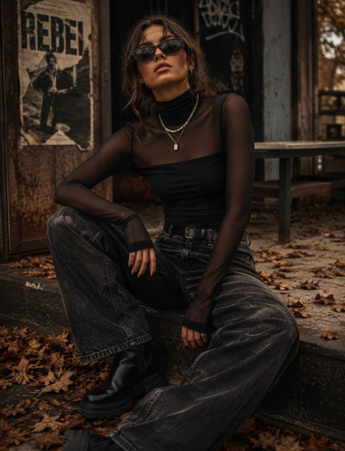 Damen Herbst Outfit mit schwarzem transparentem Mesh Top, schwarzer Wide Leg Jeans und Boots im rebellischen Streetstyle