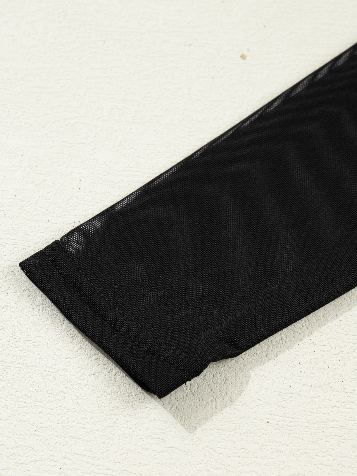 Ärmeldetail des Damen-Mesh-Tops mit langem transparentem Ärmel und schmalem Abschluss