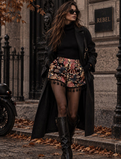 Paisley Shorts für Damen mit Quasten am Saum kombiniert mit Boots und langem Mantel für den Herbst