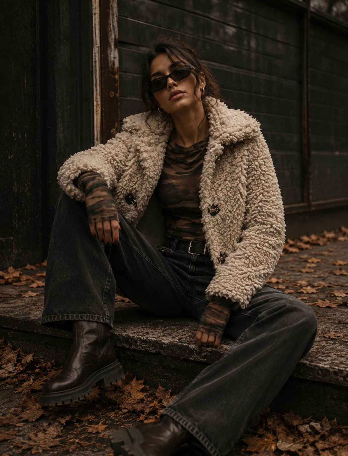 Beige Teddyjacke für Damen mit breitem Kragen kombiniert mit Camouflage-Top und dunkler Wide-Leg-Jeans im herbstlichen Rebel Streetstyle