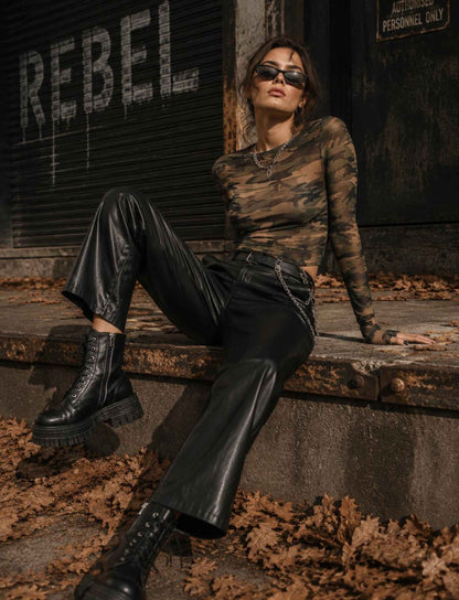 Camouflage Mesh-Top für Damen mit langen Ärmeln kombiniert mit schwarzer Lederhose und Boots im herbstlichen Rebel Streetstyle
