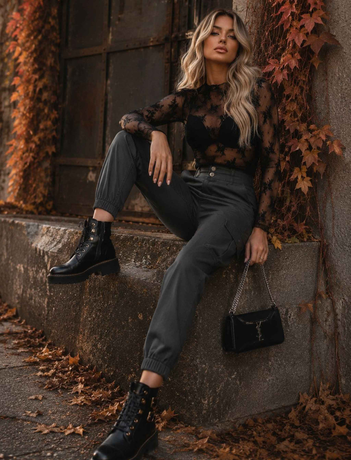 Schwarzer transparenter Spitzenbody für Damen mit langen Ärmeln kombiniert mit grauer Cargo-Joggerhose und schwarzen Boots im herbstlichen Rebel Streetstyle
