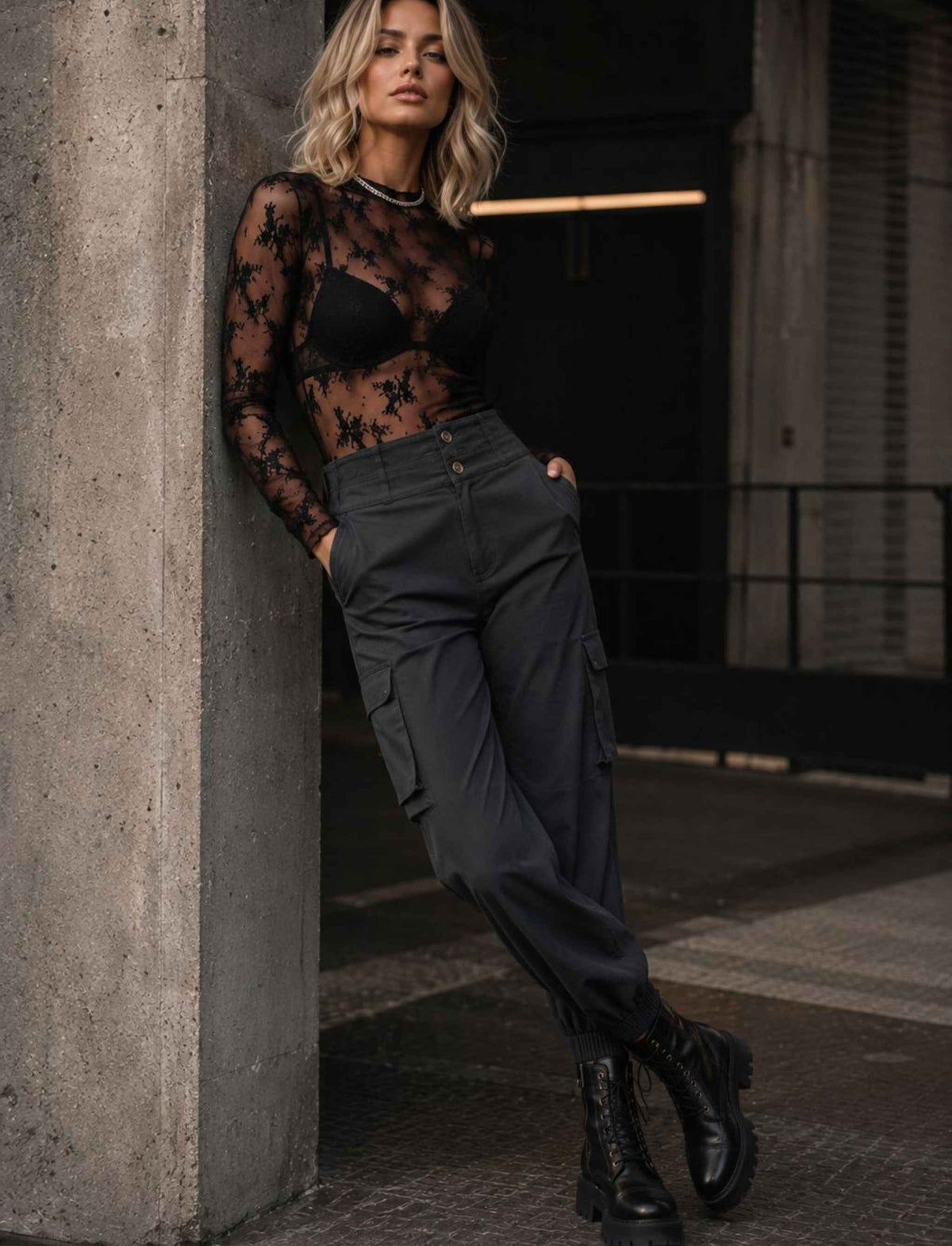 Schwarzer transparenter Spitzenbody für Damen mit langen Ärmeln kombiniert mit dunkler Cargo-Hose und schwarzen Schnürboots im herbstlichen Rebel Streetstyle