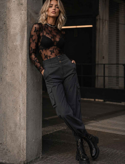 Schwarzer transparenter Spitzenbody für Damen mit langen Ärmeln kombiniert mit dunkler Cargo-Hose und schwarzen Schnürboots im herbstlichen Rebel Streetstyle