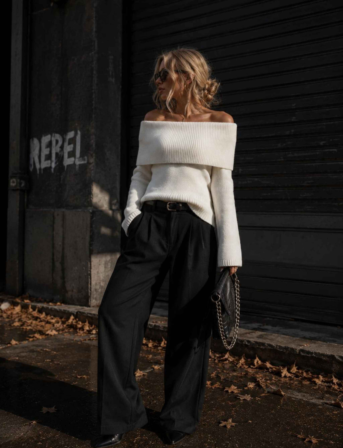 Weißer Off-Shoulder Strickpullover für Damen kombiniert mit schwarzer Wide-Leg-Hose im herbstlichen Rebel Streetstyle