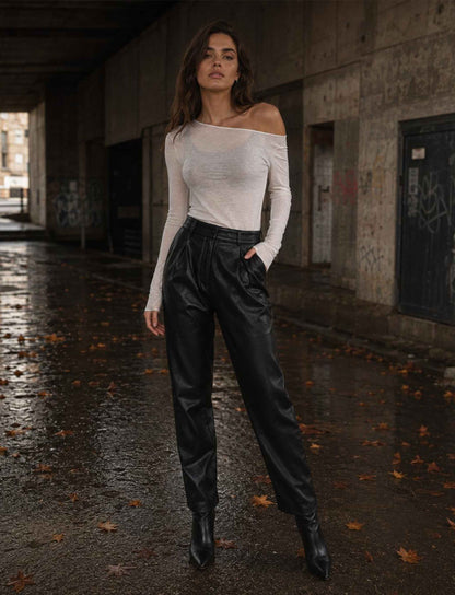 Weißes leicht transparentes Off-Shoulder Langarmshirt für Damen kombiniert mit schwarzer Lederhose und Stiefeletten im herbstlichen Rebel Streetstyle